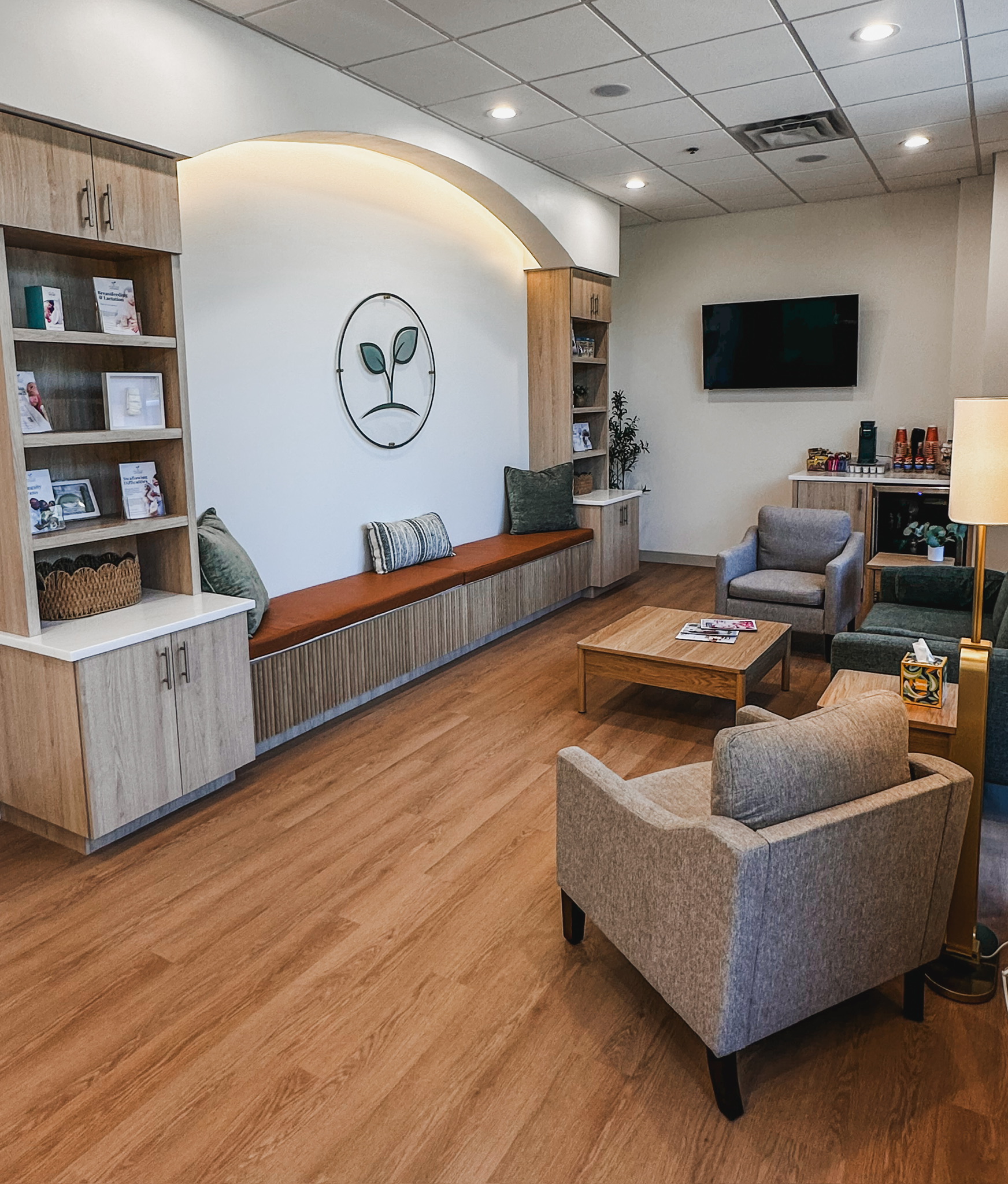Clinic waiting area with built-in bench, armchairs and a television