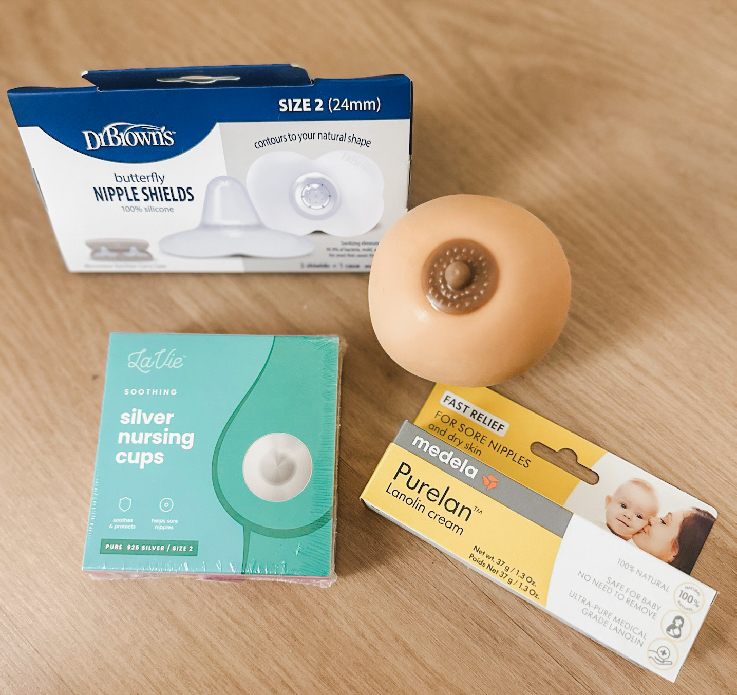Nipple shields and breastfeeding supplies on a wooden surface
