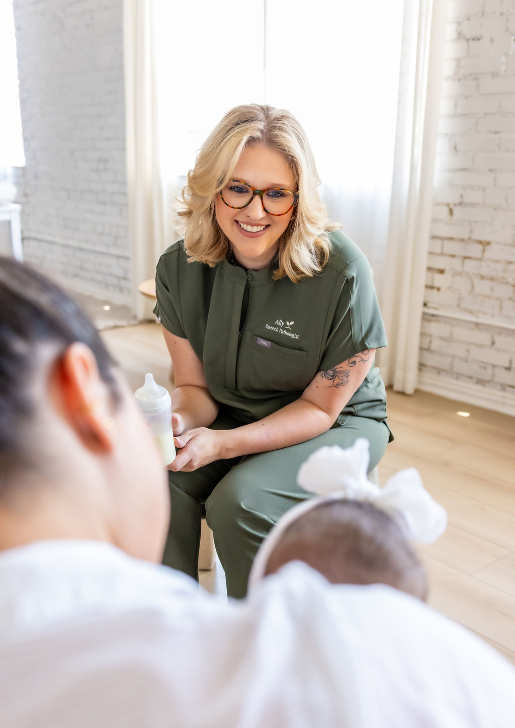 Ally Gore holding a baby bottle while talking with a family