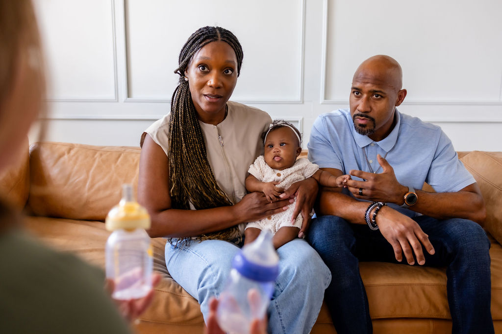 Parents holding their infant during a feeding conversation with a clinician