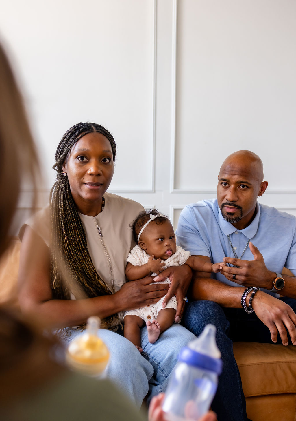 Parents holding their infant while talking with a clinician about bottles
