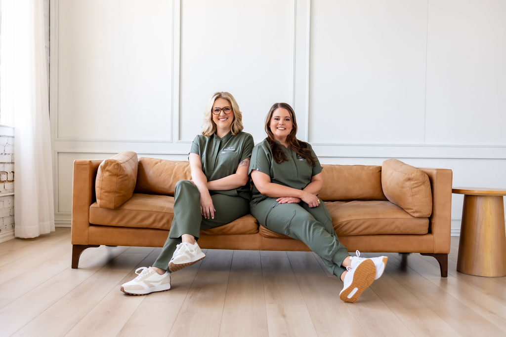 Co-founders Ally Gore and Brittany Shockley seated together in green scrubs